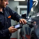 Mechanic using car diagnostic equipment