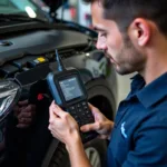 Mechanic using latest car diagnostic scanner to diagnose engine problem