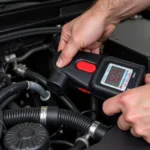 Mechanic using an EVAP leak detector tool