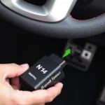 Mechanic connecting the mobile car diagnostics n14 device to a vehicle's OBD-II port