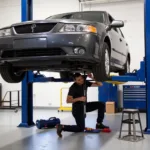 Mechanic working on a car raised on a rolling tool