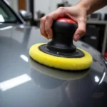 Car palm buffing tool in use on a car hood