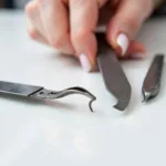 Technician meticulously inspecting nail files and clippers for any signs of wear and tear, cracks, or rust.