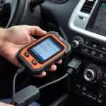 Mechanic using a compact car diagnostic tool to troubleshoot a vehicle