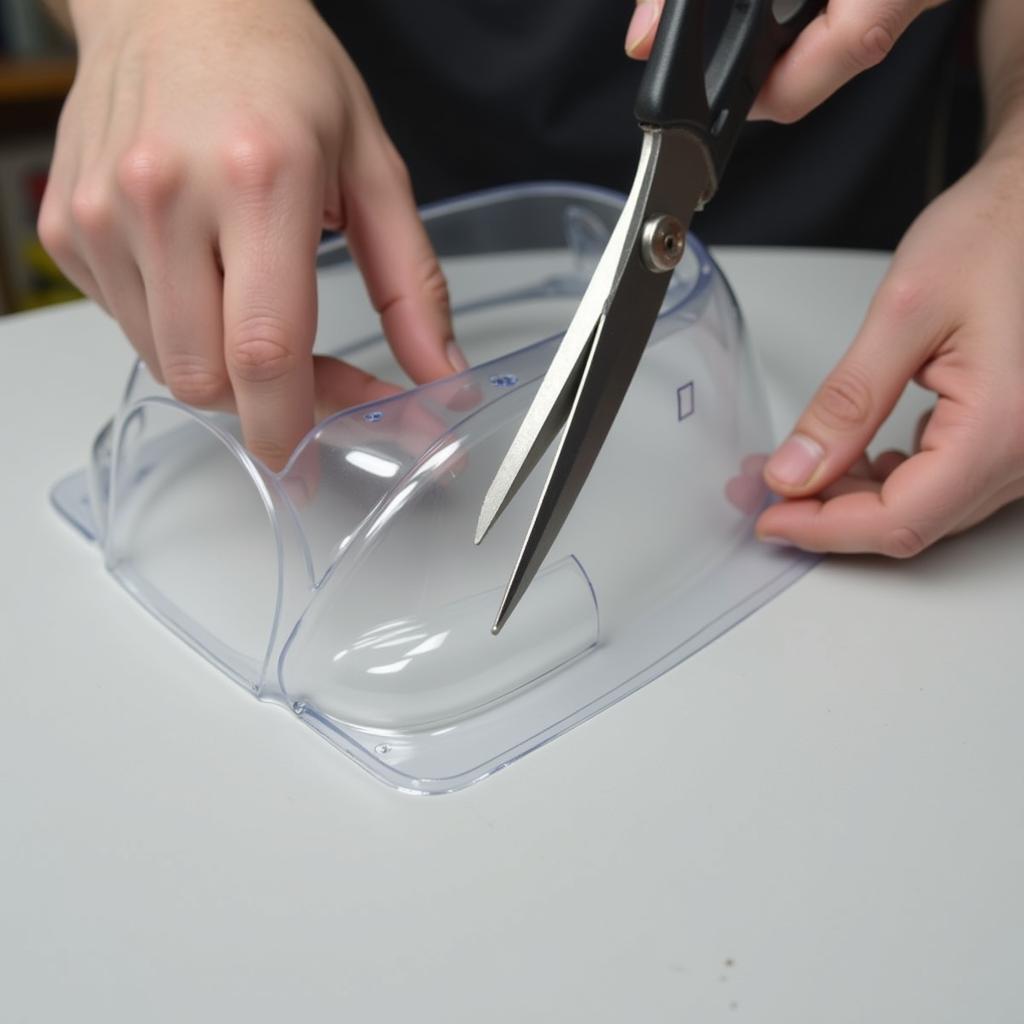 Curved scissors precisely trimming a lexan car body