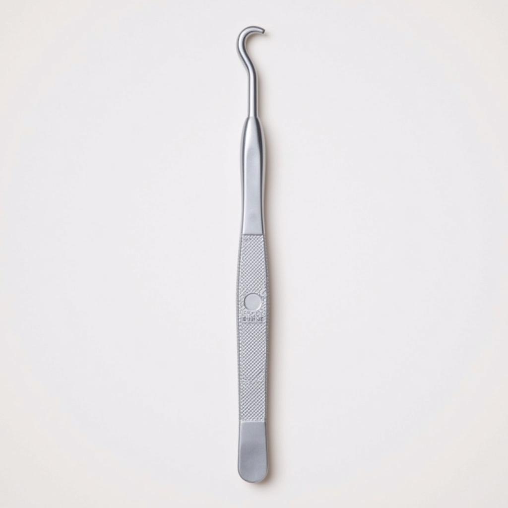 A close-up of a metal cuticle pusher, highlighting its delicate tip and ergonomic handle. 