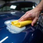 Foam applicator being used to apply wax to a car's hood