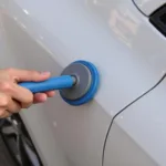 Using a suction cup dent puller on a car door