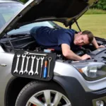 Mechanic using a magnetic car mat while working under the hood