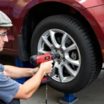 Mechanic using an impact wrench to remove a wheel.