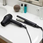 Professional hair dryer and styling iron on a vanity table.