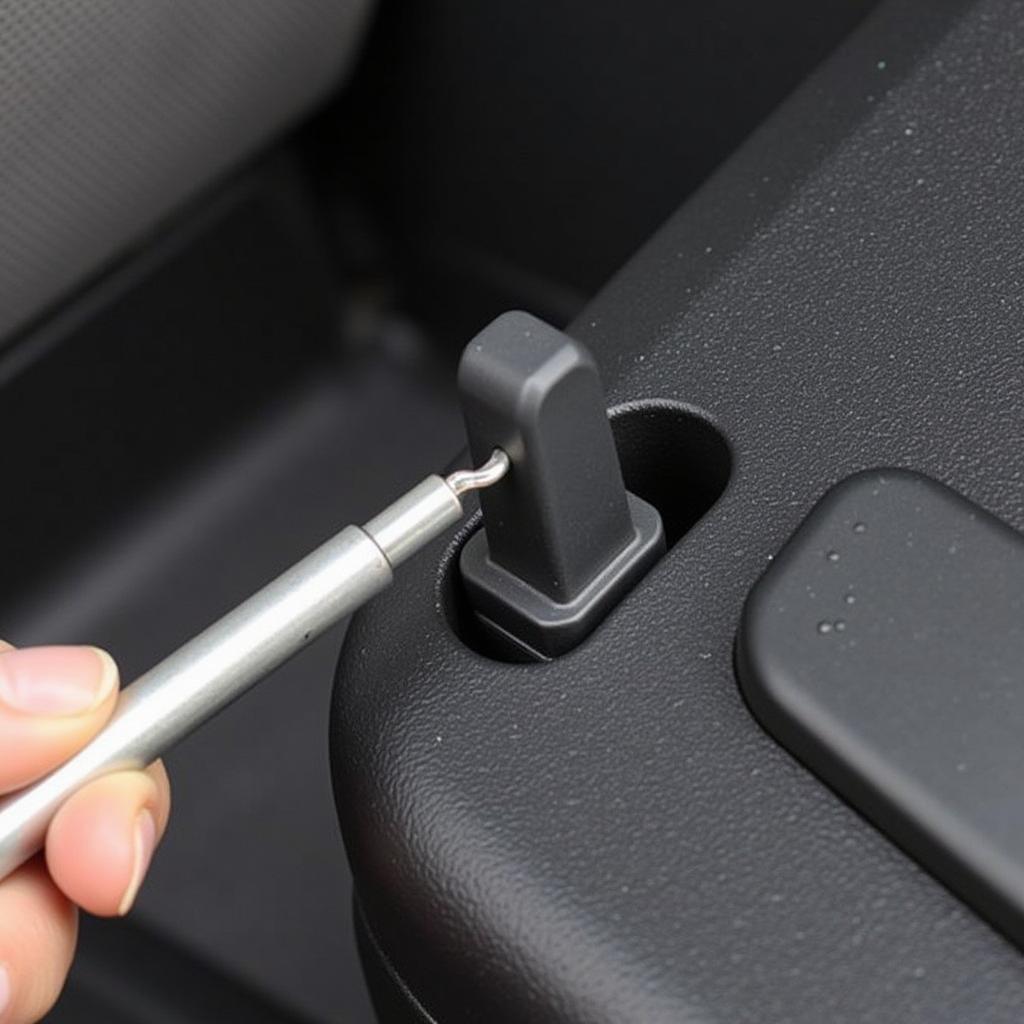 Removing Stubborn Car Boot Clip with Metal Pick: A metal pick is used to carefully pry a stubborn clip from its housing.