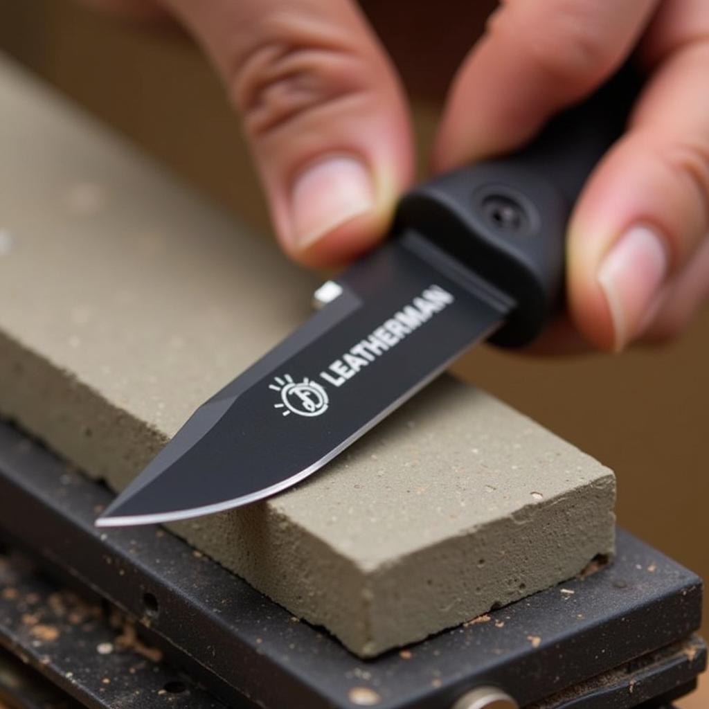 Sharpening the knife blade of a Leatherman multi-tool using a sharpening stone, maintaining a sharp edge for optimal cutting performance.