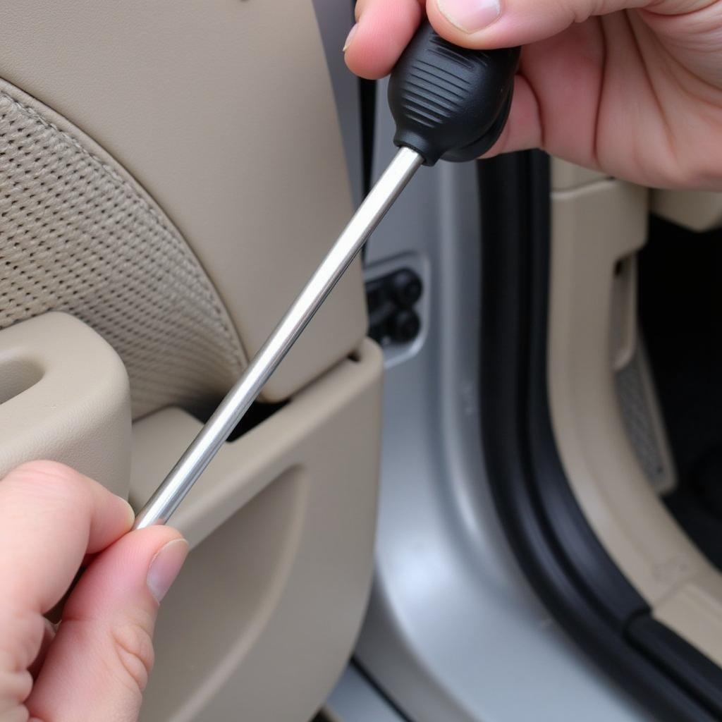 Using Trim Removal Tool on Car Door Panel