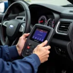 Mechanic using a diagnostic tool to reset a service light