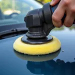 Car polishing tool attached to a drill being used on a car's hood.