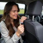 Woman struggling to unbuckle a car seat with long nails