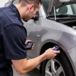 Mechanic using a Foxwell scanner to diagnose a car.