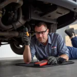 Mechanic Using Steelman Car Sounds Tool Under Car