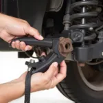 Nutcracker car tool removing a rusted nut from a car's suspension system