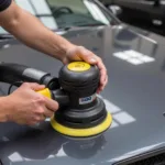 Orbital sander being used to remove paint from a car