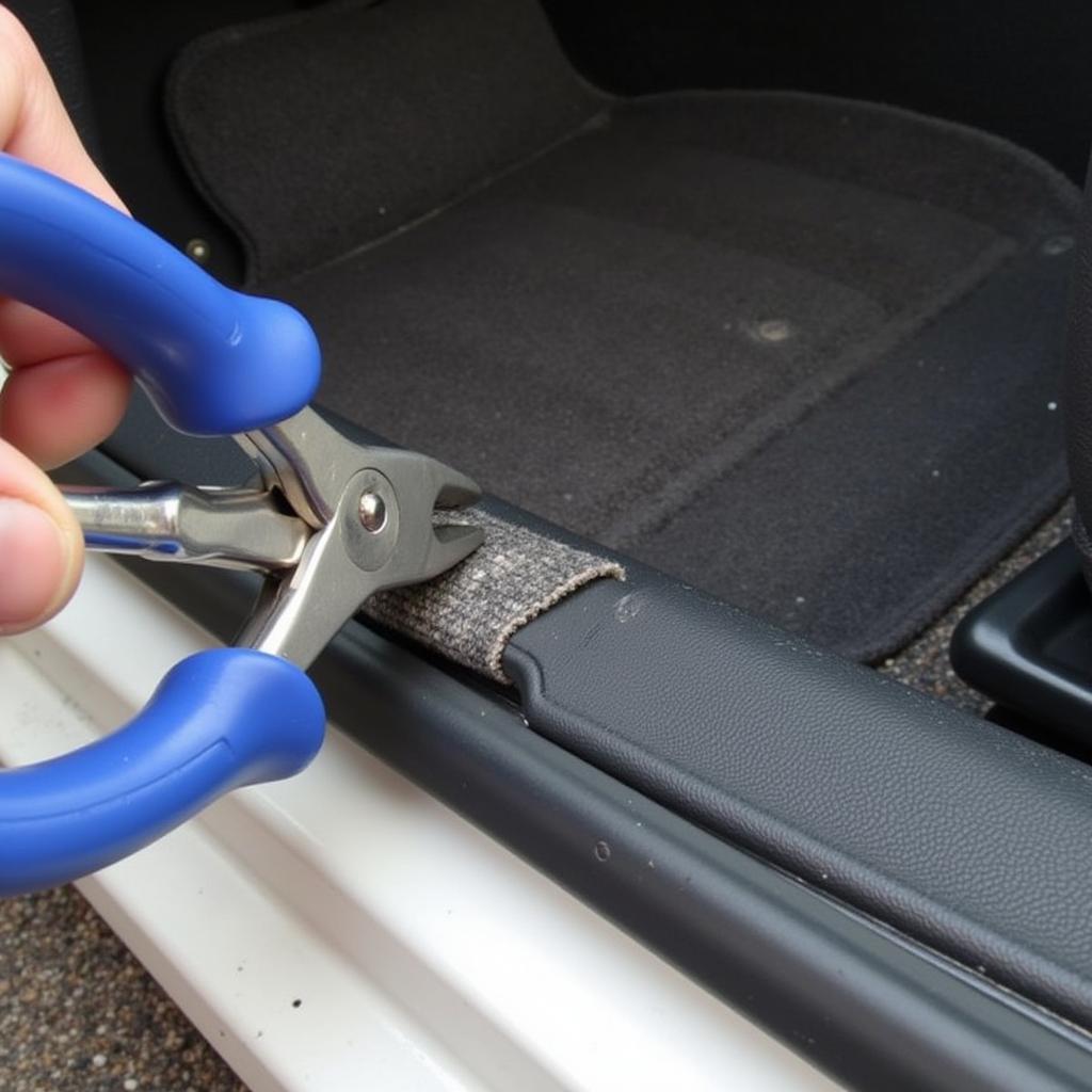 Using pliers to remove a stubborn carpet tack strip.