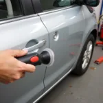 Suction cup dent puller removing a small dent from a car door