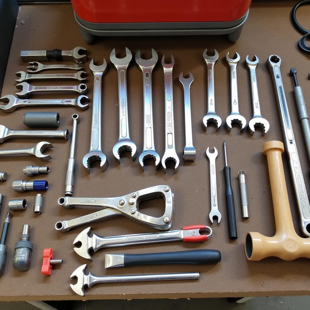 Used hand tools for car repair spread out on a workbench.