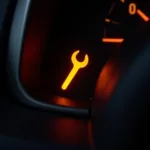 Wrench tool light illuminated on a car's dashboard.